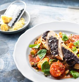 Kycklingfilé toppad med oliv på en bädd av tomat, zucchini & kapris