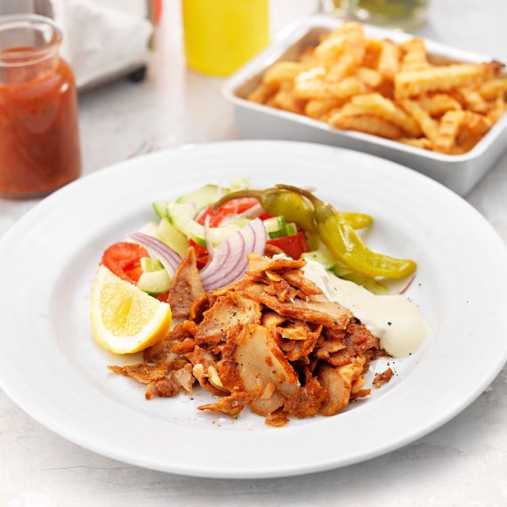 Kycklingkebabtallrik med myntayoghurt, harissadressing & pommes